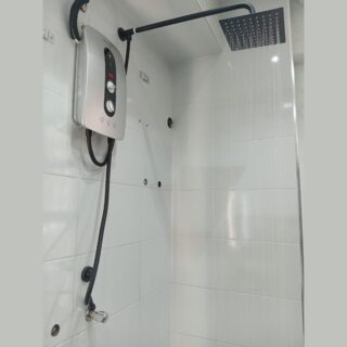 Grey instant water heater with inbuilt booster pump and elegant black top shower mounted on a modern bathroom wall, featuring a 5.5KW red copper heating system and sleek contemporary design.